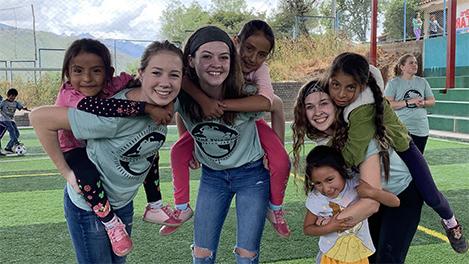 Cedarville students playing with kids in outdoor gym